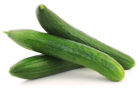 three fresh cucumbers on a white backgroundの写真素材