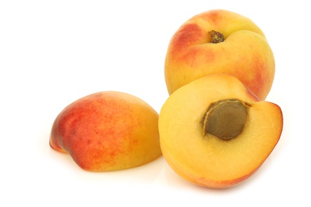 fresh colorful apricot and a cut one on a white backgroundの写真素材
