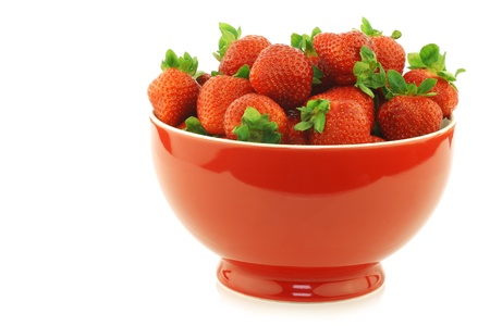 fresh strawberries in a red ceramic bowl on a white backgroundの写真素材