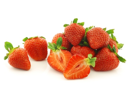 fresh strawberries and a cut one on a white backgroundの写真素材