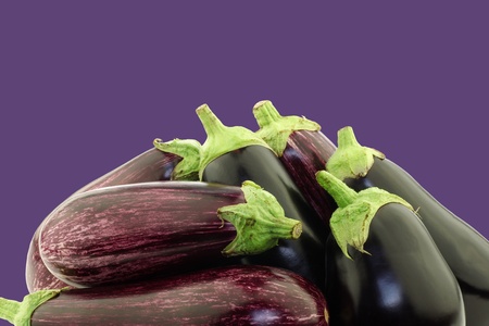 mixed aubergines on a purple background with copy spaceの写真素材