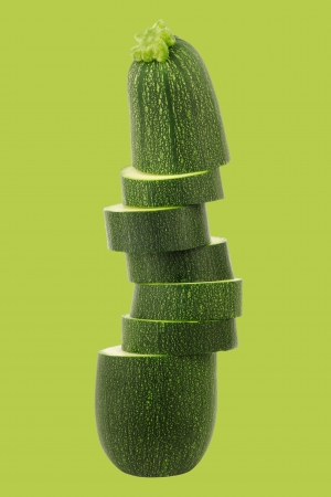 one cut zucchini  Cucurbita pepo  on a green backgroundの写真素材