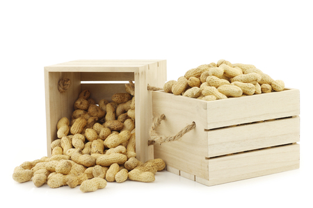 bunch of roasted peanuts in wooden boxes with rope handles on a white backgroundの写真素材