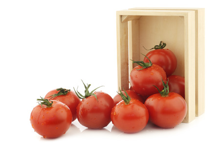 fresh tomatoes in a wooden box on a white backgroundの写真素材