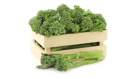 A small form of broccoli, called bimi, in a wooden box on a white backgroundの写真素材