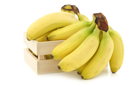 fresh mini bananas in a wooden box on a white backgroundの写真素材