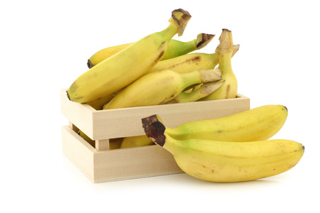 fresh mini bananas in a wooden box on a white backgroundの写真素材