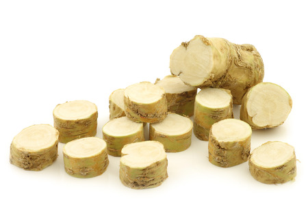 freshly harvested cut horseradish pieces on a white backgroundの写真素材