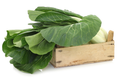 fresh chinese paksoi in a wooden crate on a white backgroundの写真素材