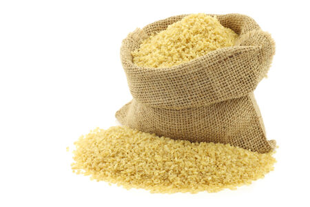 bulgur (couscous) in a burlap bag  on a white backgroundの写真素材