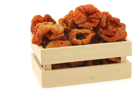 dried red bell peppers in a wooden box on a white backgroundの写真素材