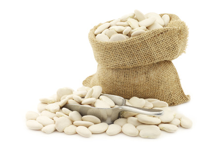 Butter beans (lima beans) in a burlap bag on a white backgroundの写真素材