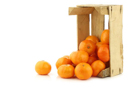 bunch of fresh tangerines in a wooden box on a white backgroundの写真素材