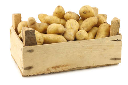 original french \"ratte\"potatoes (Solanum tuberosum) in a wooden crate on a white backgroundの写真素材