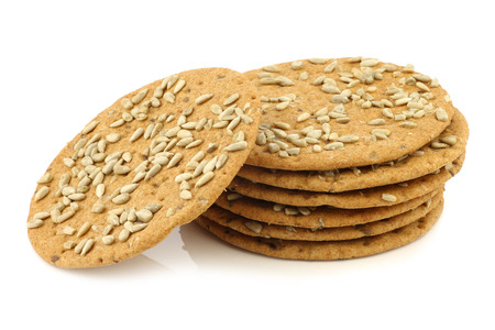 stacked crispy spelled crackers with sunflower seeds on a white backgroundの写真素材