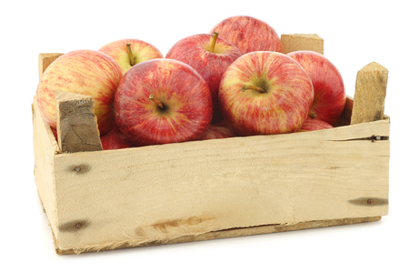 fresh sweet apples in a small wooden crate on a white backgroundの写真素材