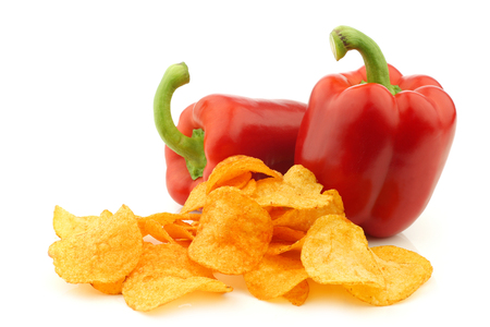 two red bell peppers and paprika chips on a white backgroundの写真素材