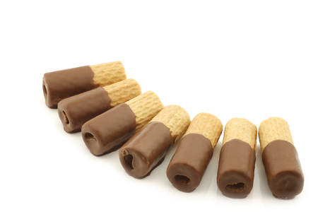 rolled up crispy chocolate wafers on a white backgroundの写真素材