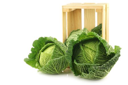 Fresh green cabbages in a wooden crate on a white backgroundの写真素材