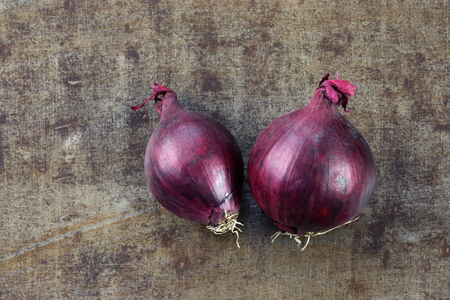 two red onions on a grungy metal backgroundの写真素材