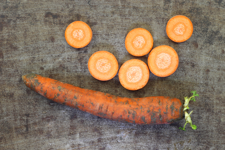Winter carrot and some slices on a grungy metal backgroundの写真素材