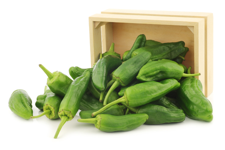 Freshly harvested jalapeno peppers in a wooden crate on a white backgroundの写真素材