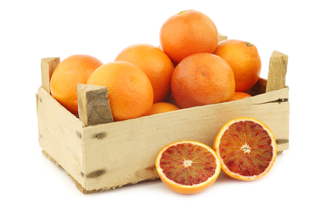 fresh blood oranges in a wooden crate on a white backgroundの写真素材