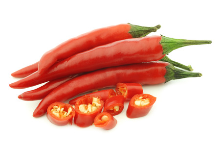 red rawit peppers (Capsicum annuum 'Bird's Eye') and a cut one on a white backgroundの写真素材