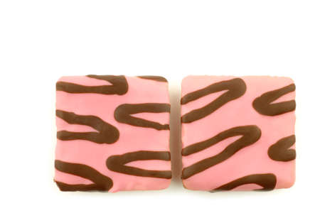 freshly baked square pink glazed cake with chocolate dressing on a white backgroundの写真素材