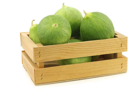 unripe baking bananas (plantain bananas) in a wooden crate on a white backgroundの写真素材