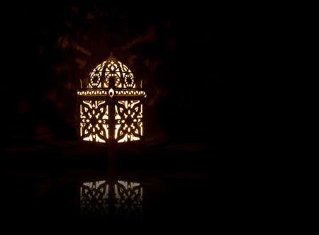 Decorative Lantern with Burning Candle Inside on Black Backgroundの写真素材