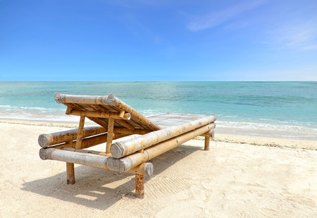 Relaxing Chair on white sandy Beach looking toward ocean and blue skyの写真素材