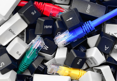 Close-up on Pile of Black and White Computer Keyboard Keys with Colorful network cables