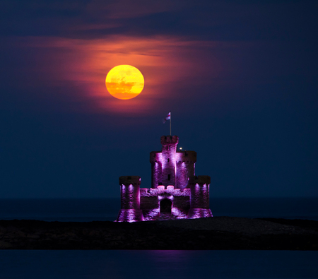Red Blood moon rising over Tower of Refuge, Isle of Manの写真素材