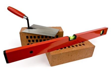 Bricks, level and trowel on a white background shown.の写真素材