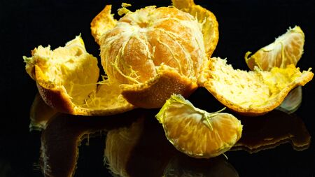 Peeled tangerine on a black backgroundの写真素材