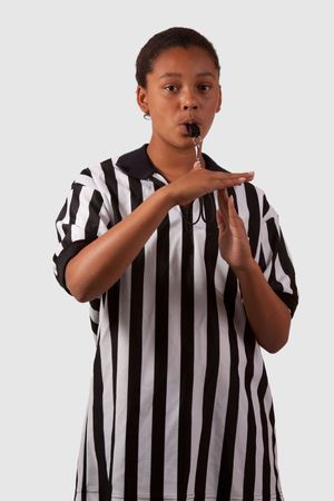 Young african american girl wearing a black and white striped referee top blowing a whistleの写真素材