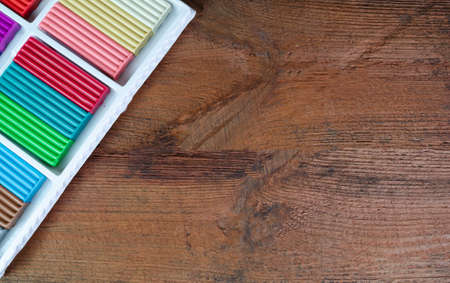 Multicolored plasticine in a box on a wooden background.の写真素材