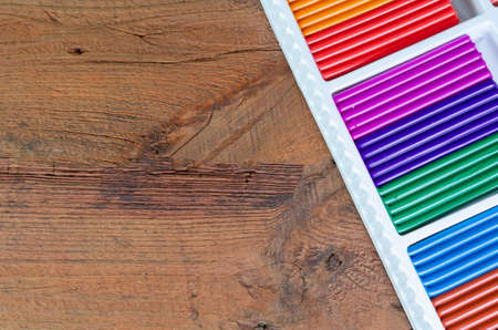 Colorful plasticine in a box on a wooden background. Copy space.の写真素材