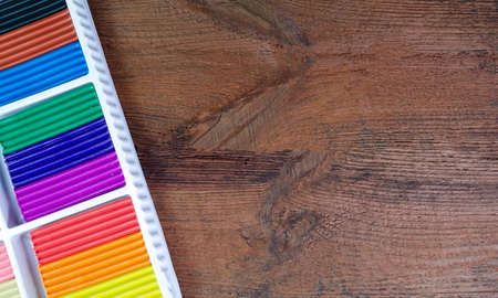 Colorful markers in a box on a wooden background, space for textの写真素材