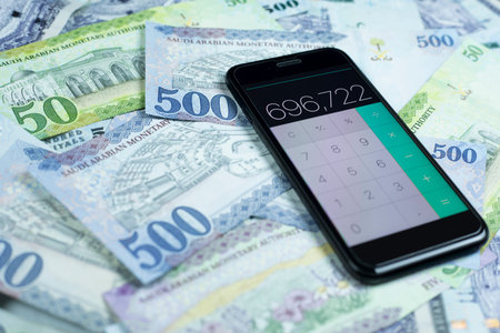 Saudi Riyals notes with phone