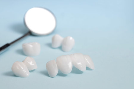 Dental mirror and dentures on a light blue background