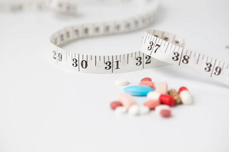Measuring tape with some medicines, the photo express the diet and nutritionの写真素材