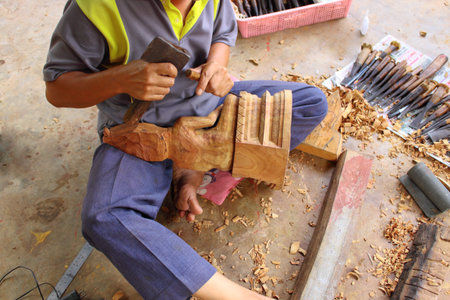 Carving craftsman is carving wood for Buddha modelの写真素材