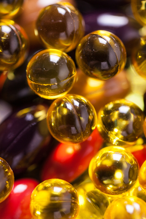 a scattering of colored capsules and tablets, close-up, photograph with depth of fieldの写真素材