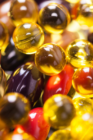 a scattering of colored capsules and tablets, close-up, photograph with depth of fieldの写真素材