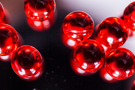 red capsules on mirror background, macro, photo with depth of fieldの写真素材