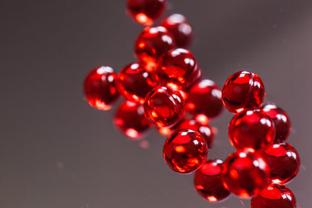 red capsules on mirror background, macro, photo with depth of fieldの写真素材