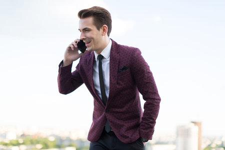 young man talking on the phone on the background of the cityの写真素材