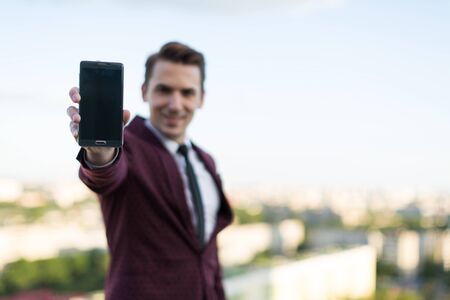 young guy is holding a phone in his hand
electric focus on phoneの写真素材